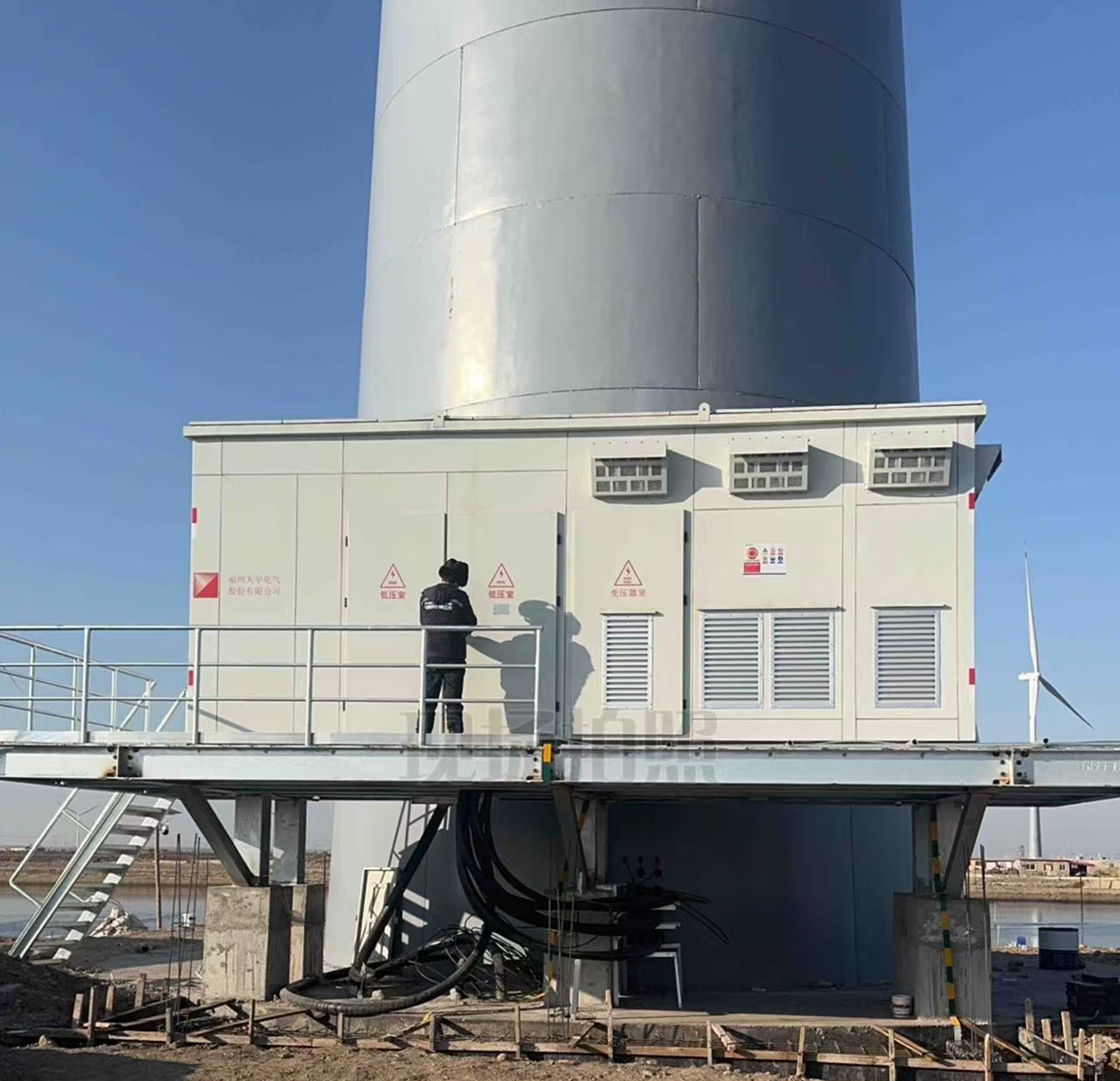 Hua-style compact substation enclosure at the base of a wind turbine tower